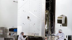 Two engineers from Lockheed Martin prepare the first GPS III satellite for system-level testing at the company&rsquo;s Denver-area satellite facility earlier this year. (Image courtesy of Lockheed Martin).