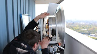 An engineer tuning the E band transmitters within a parabolic antenna (Image courtesy of J&ouml;rg Eisenbeis, KIT).
