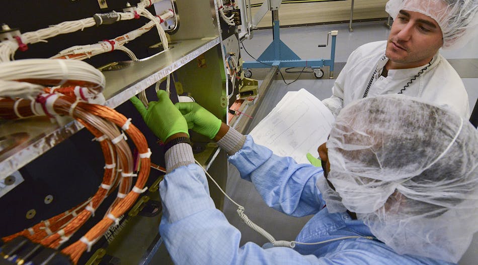 Northrop Grumman technicians in Redondo Beach, California, thread wiring and cabling through the fourth protected communications payload for the U.S. Air Force&apos;s Advanced Extremely High Frequency satellite system. (photo courtesy of Northrop Grumman)