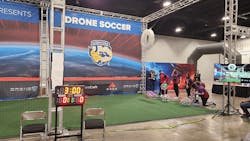 2. The timed competition takes place in a walled-off area, with students using game controllers to pilot the remote-control drone balls.